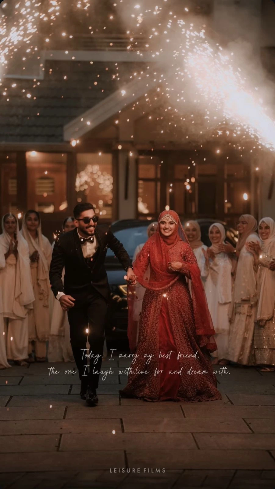 Joyful newlywed couple holding hands and walking under sparkling fireworks, with bridesmaids cheering behind, beautifully captured by the best wedding photographer in Calicut