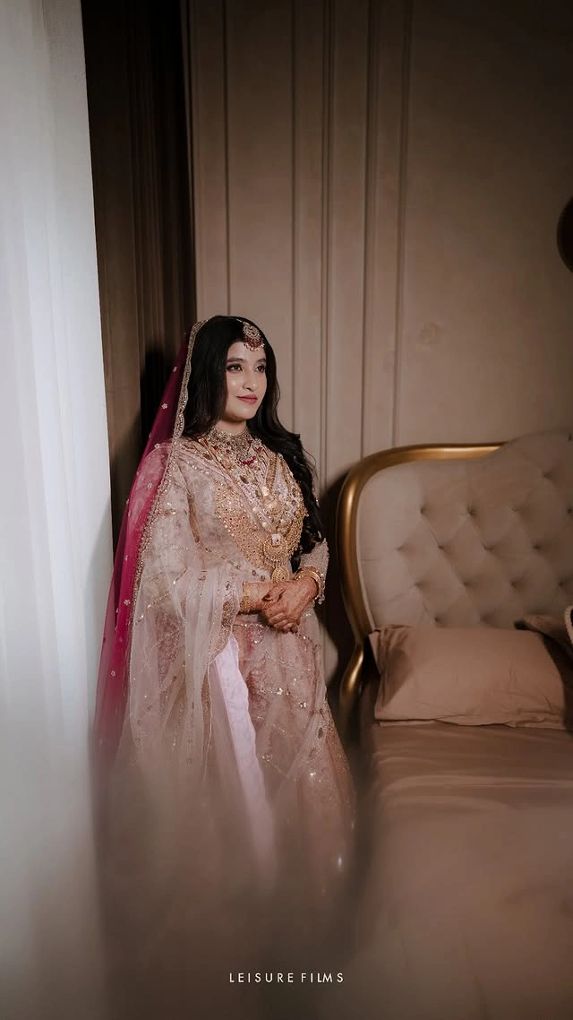"Elegant bride in a pink and gold lehenga captured by the best wedding photographer in Calicut."